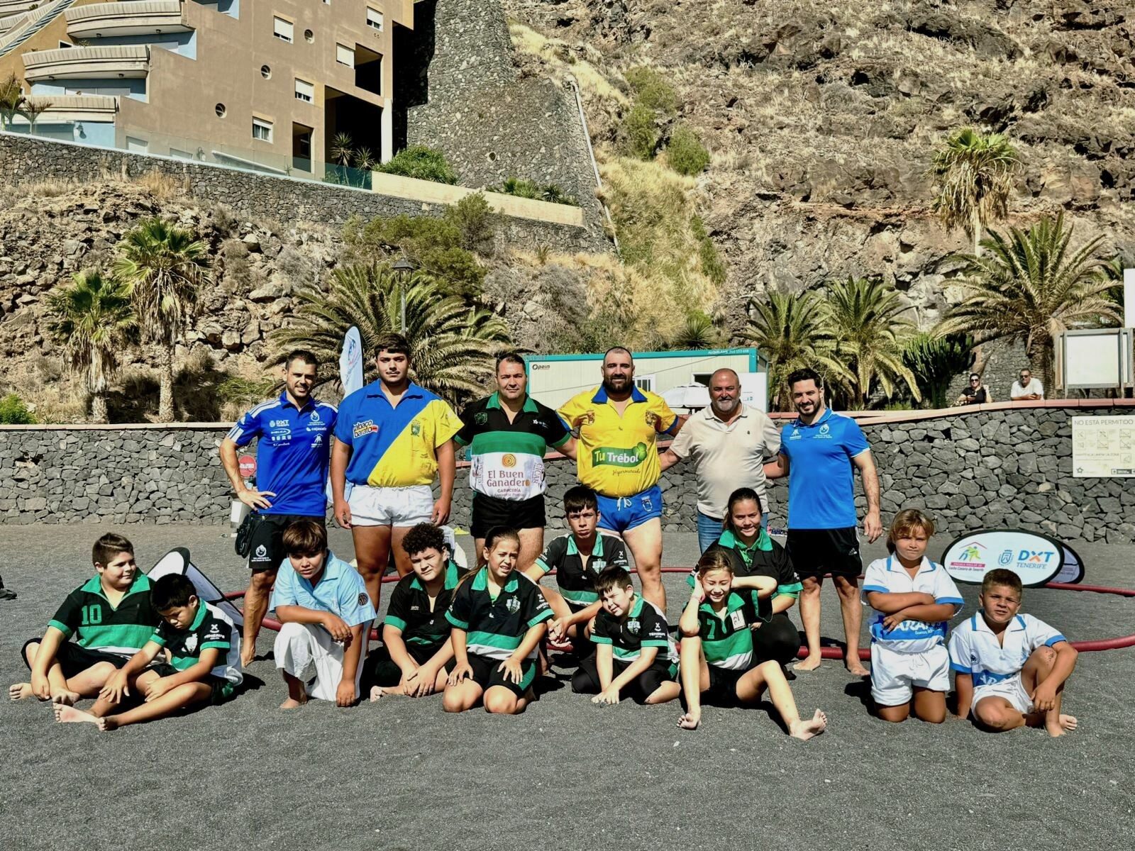 Luchadores posando en la playa junto con el alcalde