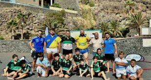 Luchadores posando en la playa junto con el alcalde